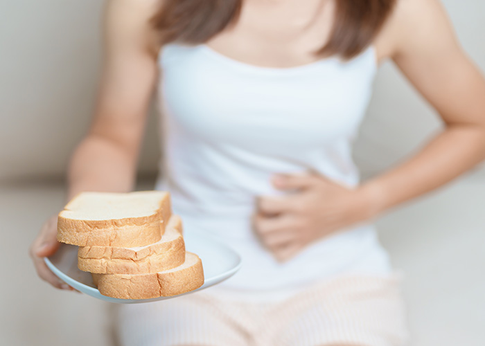 woman feeling uncomfortable after consuming bread