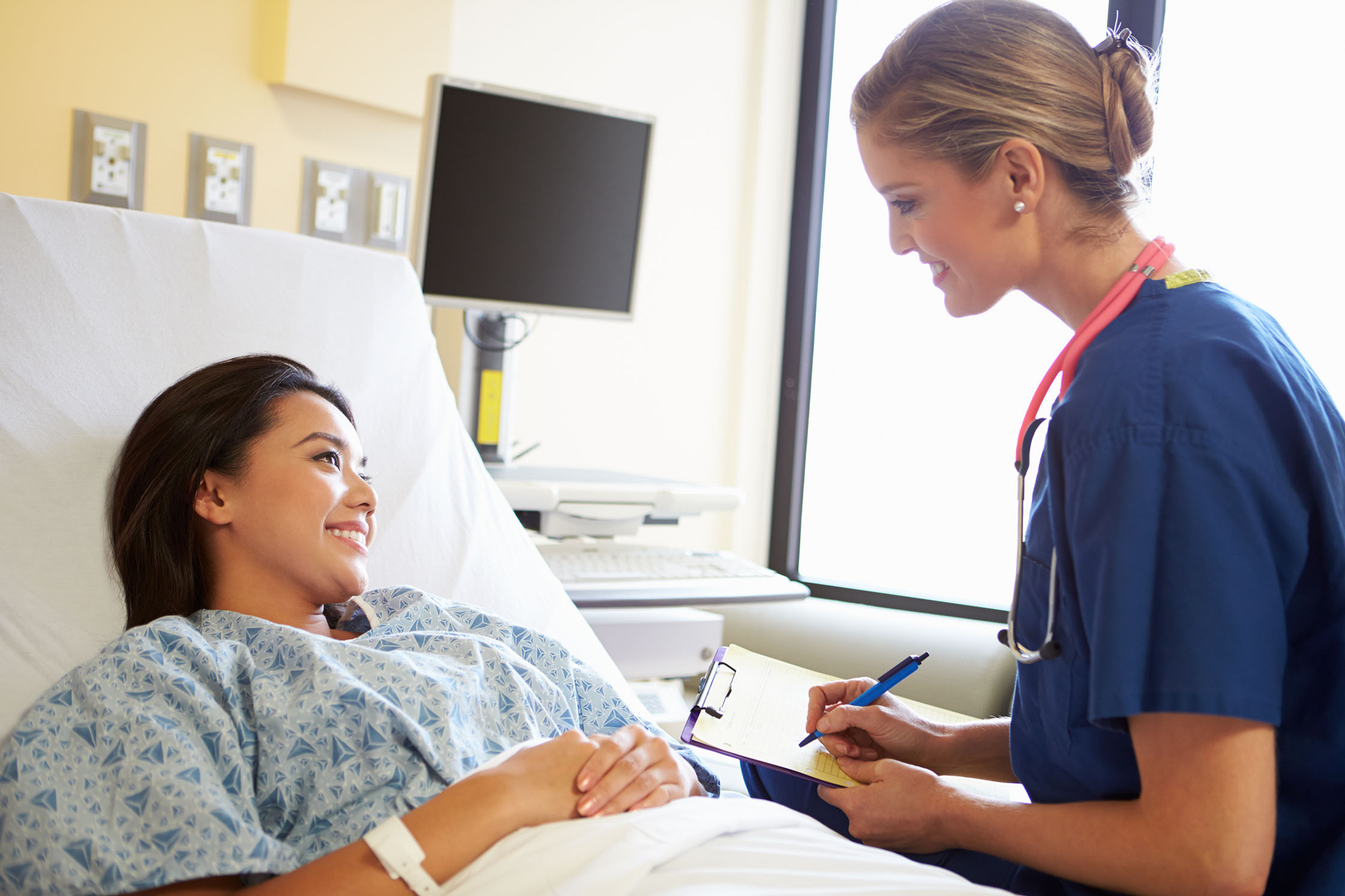 woman smiling with physician taking notes